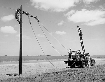 Rural Electrification Administration (REA) erects telephone lines in rural areas. Photo courtesy of National Archives and Records Administration. Rural Electrification Administration (REA) erects telephone lines in rural areas. Photo courtesy of National Archives and Records Administration.